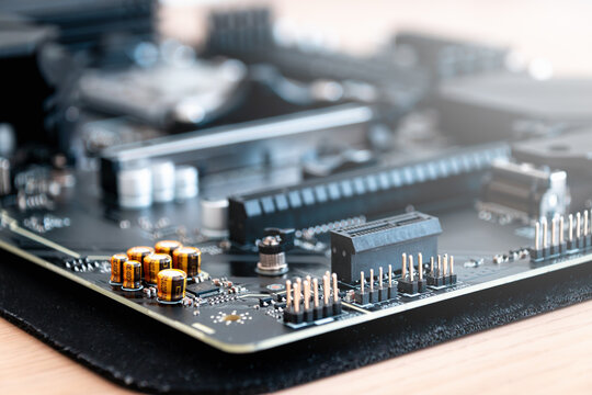 Motherboard close view showing capacitors pins and connectors on desk