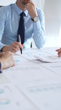 Business professionals analyzing financial charts and graphs during corporate meeting in modern office, focusing on data strategy, growth performance, and market planning