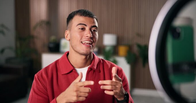 Phone, ring light and streamer with introduction for live stream, content creation and social media in home. Man, influencer and gen z person with tech for broadcast, chat and online interaction