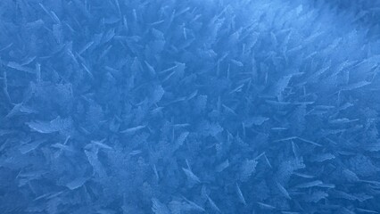 Obraz premium Macro texture of dense blue ice crystals and hoarfrost showing intricate freezing patterns and cold winter mood.