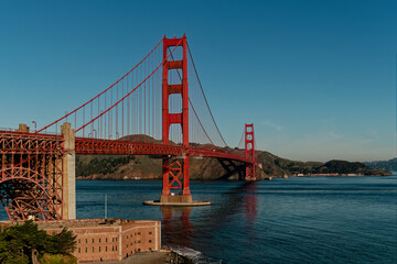 Fototapeta premium Colorful Structures Over Calm Waters. Vividly Painted Bridge Connecting Busy Harbor To Cityscape