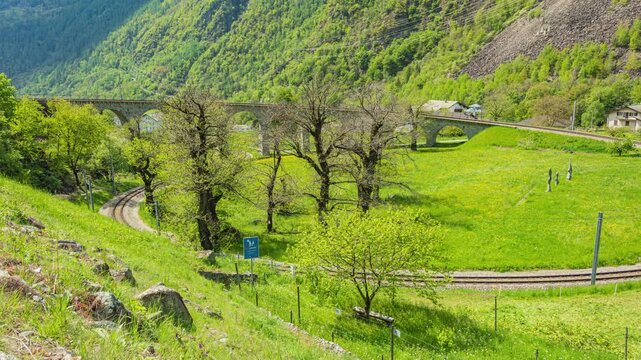 Time lapse, train going thought a stone railway spiral in the Swiss Alps. The Brusio Spiral Viaduct, canton Graubuenden, Switzerland.