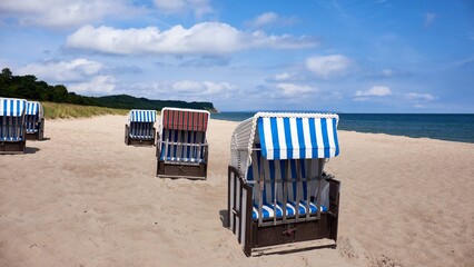 Strandkorb on Rugen beach with blue striped canopy and sandy foreground
