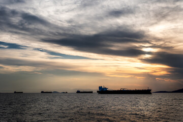 Obraz premium Crude oil tankers in the sea at sunset. Oil and gas industry. Tankers crude oil carrier ship designed for transporting grude oil