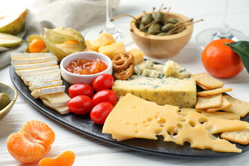 Charcuterie board with many different snacks on white wooden table, closeup