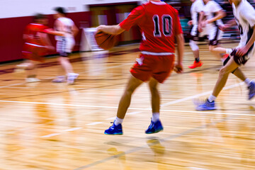 Naklejka premium High School Basketball with motion blur showing the speed and movement of the young boys playing the game at Oxford HS in Upstate NY