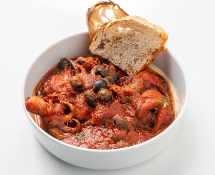 Polipetti alla Luciana, traditional Neapolitan octopus stew with tomato sauce and black olives served with toasted bread.