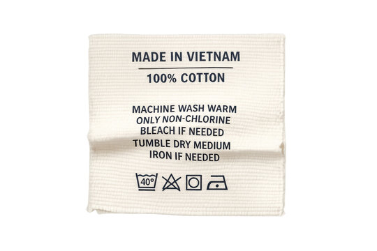 Clothing label showing cotton textile care instructions and origin