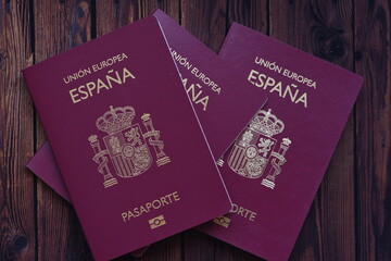 Top view of multiple passports placed on a rustic wooden table, symbolizing international travel, tourism, immigration, and global mobility. Perfect for themes like vacation planning, border control,  © Nret
