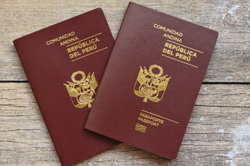 Top view of multiple passports placed on a rustic wooden table, symbolizing international travel, tourism, immigration, and global mobility. Perfect for themes like vacation planning, border control,  © Nret