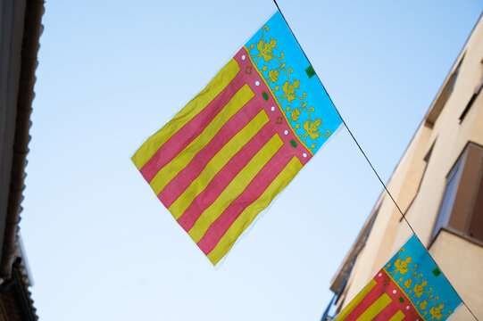 Valencia flag Senyera Coronada decorating a city street during Fallas