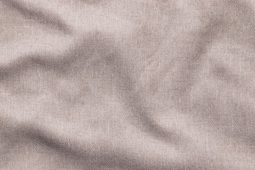 Texture of light brown linen woven fabric with wavy folds pattern, empty textured textile background