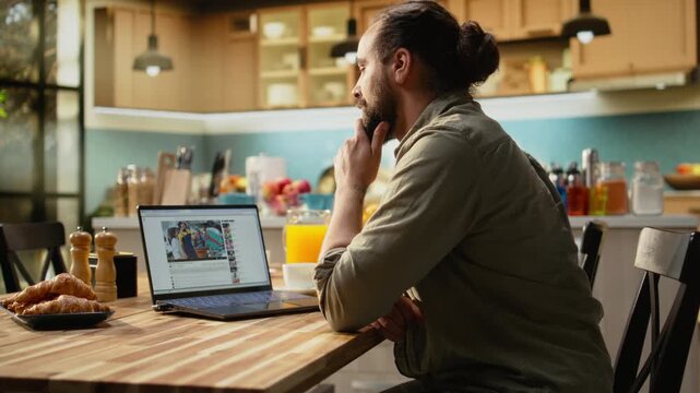 Video-sharing platform, modern man using laptop, playing video content, streaming platform. User generated content free to watch, video entertainment during casual digital lifestyle, leisure.