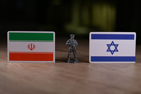 A tin soldier on the background of the flags of Iran and Israel.