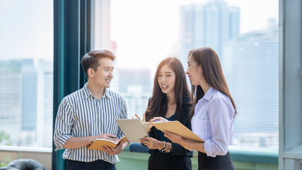 A group of Gen Z Asian business consulting, exchanging information in offices, co-working spaces. © PAPALAH
