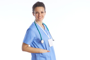 Fototapeta premium A portrait of a smiling female healthcare professional in light blue medical scrubs, standing confidently with a stethoscope, representing trust and quality patient care.