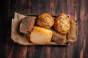 Assorted fresh bread rolls top view on rustic table