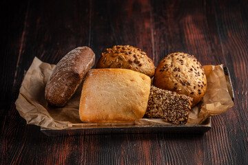 Assorted fresh bread rolls on rustic wooden table