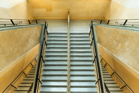 concrete staircase inside modern building interior with geometric architecture, minimalist design, clean lines, and warm textured walls.