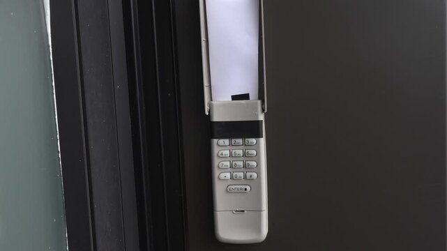Wall-mounted intercom system with paper insert visible, showcasing buttons and design in a modern indoor setting