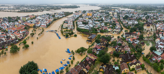 Fototapeta na wymiar Aerial view of the flooded city of Hoi An, Vietnam, during the monsoon season. The rising waters have submerged homes and businesses along the riverfront.
