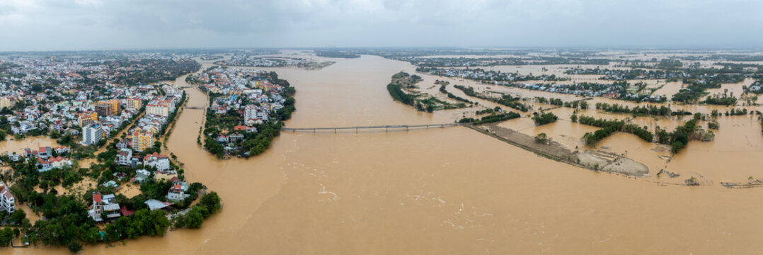 Aerial view of the flooded city of Hội An, Vietnam, during a period of extreme flooding. Homes and businesses are underwater due to the rising river levels.