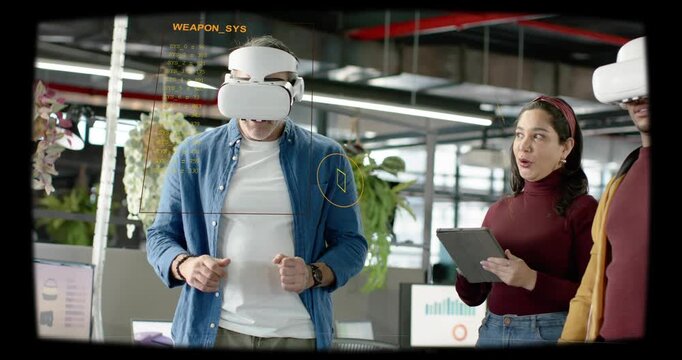 Vertical video: Man donning VR headset testing tech demo woman checking tablet HUD bracketing hands