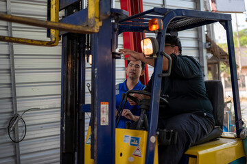 Forklift operator receiving training from technician © Wasana