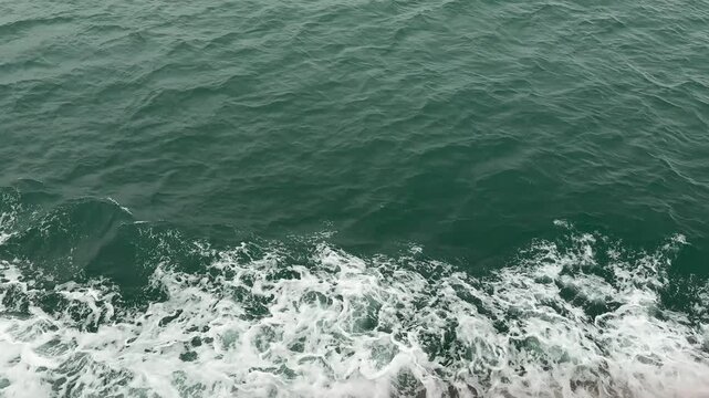 Original 4K 120fps high frame rate (HFR) top-down shot of deep emerald green ocean water churning with white sea foam. Real-time playback, perfect for custom speed ramping or hyper-smooth video editin