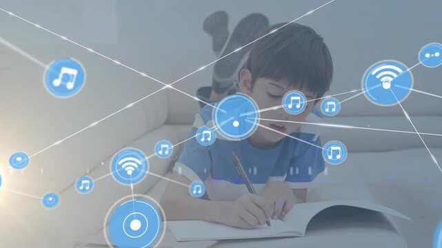 Schoolboy lying on couch writing notebook and activating education overlay of music Wi-Fi nodes