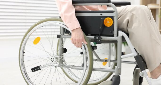 Woman using wheelchair at home, closeup view