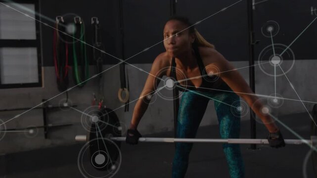 Woman lifter pulling barbell driving overhead while training power in gym network overlay spreading