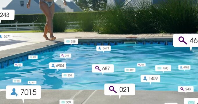 Adult woman walking pool edge, crouching then jumping, creating splash sending floating tech labels
