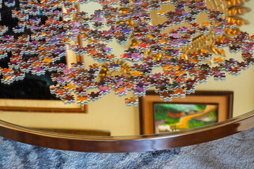 Artistic Shot of Scattered Jigsaw Puzzle Pieces on Reflective glass Table in Elegant Home Interior