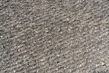 Scraped old road surface  coarse texture of a milled road reveals stone aggregates after asphalt removal. road renovation and preparation © ArieStudio