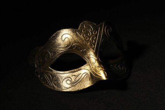 Beautiful golden carnival mask on black background, closeup