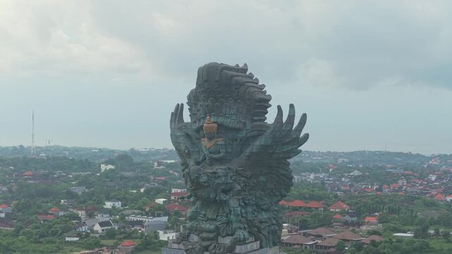 Aerial perspective of the massive garuda wisnu kencana - gwk - statue, a prominent cultural landmark overlooking the lush bali landscape