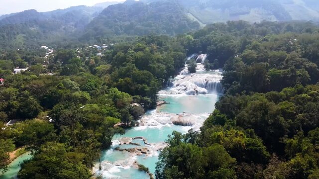 Aerial drone view of Agua Azul's layered waterfalls and natural turquoise pools formed by mineral deposits in the Chiapas jungle