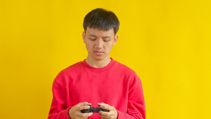 Concentrated Young Man in Red Sweatshirt Playing Video Games with Controller © Gatot