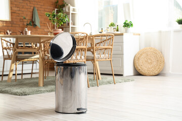 Open trash bin on floor in kitchen