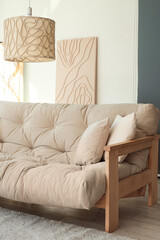 Fototapeta premium Light interior of modern living room with comfy sofa, pillows and lamp