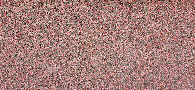 Red textured surface of small aggregate and gravel asphalt material