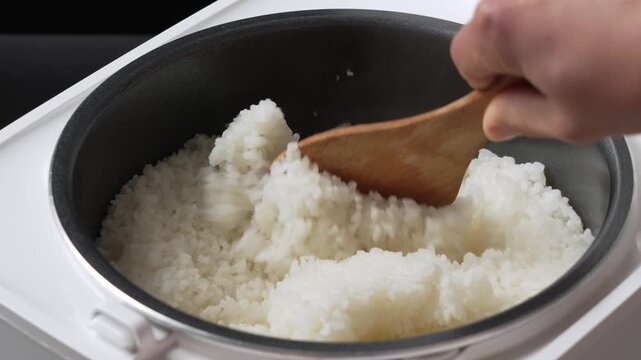 cooked rice with a spatula in electric cooker