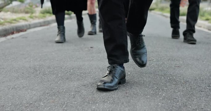 People, feet and walking at cemetery with funeral procession, solidarity and burial ceremony outdoor. Person, shoes and journey in graveyard with family mourning, memorial service and grief together.