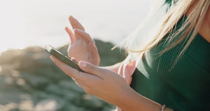 Hands, phone and texting at beach on vacation with scroll, chat or online dating in summer on rocks. Woman, smartphone and click with mobile app, contact and social media on seaside holiday by ocean
