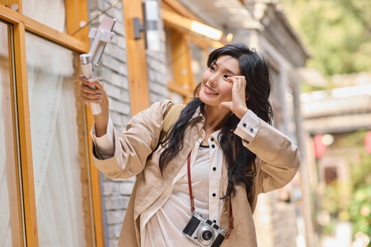 Happy female influencer webcasts while traveling