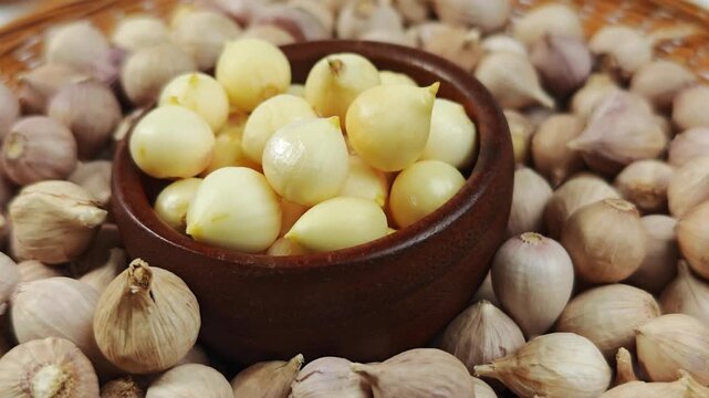Single clove garlic herb in a wooden cup.