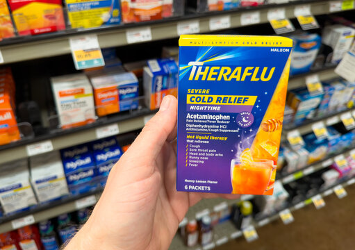 Theraflu Severe Cold Relief Powder Packets Box Held In Hand In Pharmacy Store Aisle