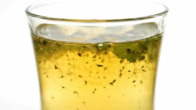 Extreme close-up of refreshing herbal iced tea or mojito isolated on white, showing liquid texture and fresh mint leaves in a glass cup, suitable for beverage and healthy drink concepts.