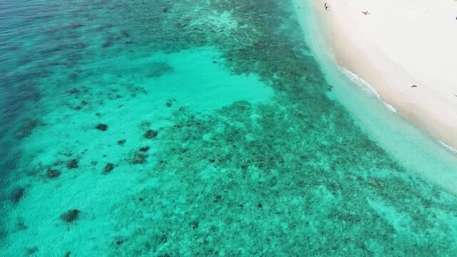 Cinematic birds-eye view of a beach in Ukulhas, Maldives. Beautiful contrast between white sand and clear turquoise ocean.